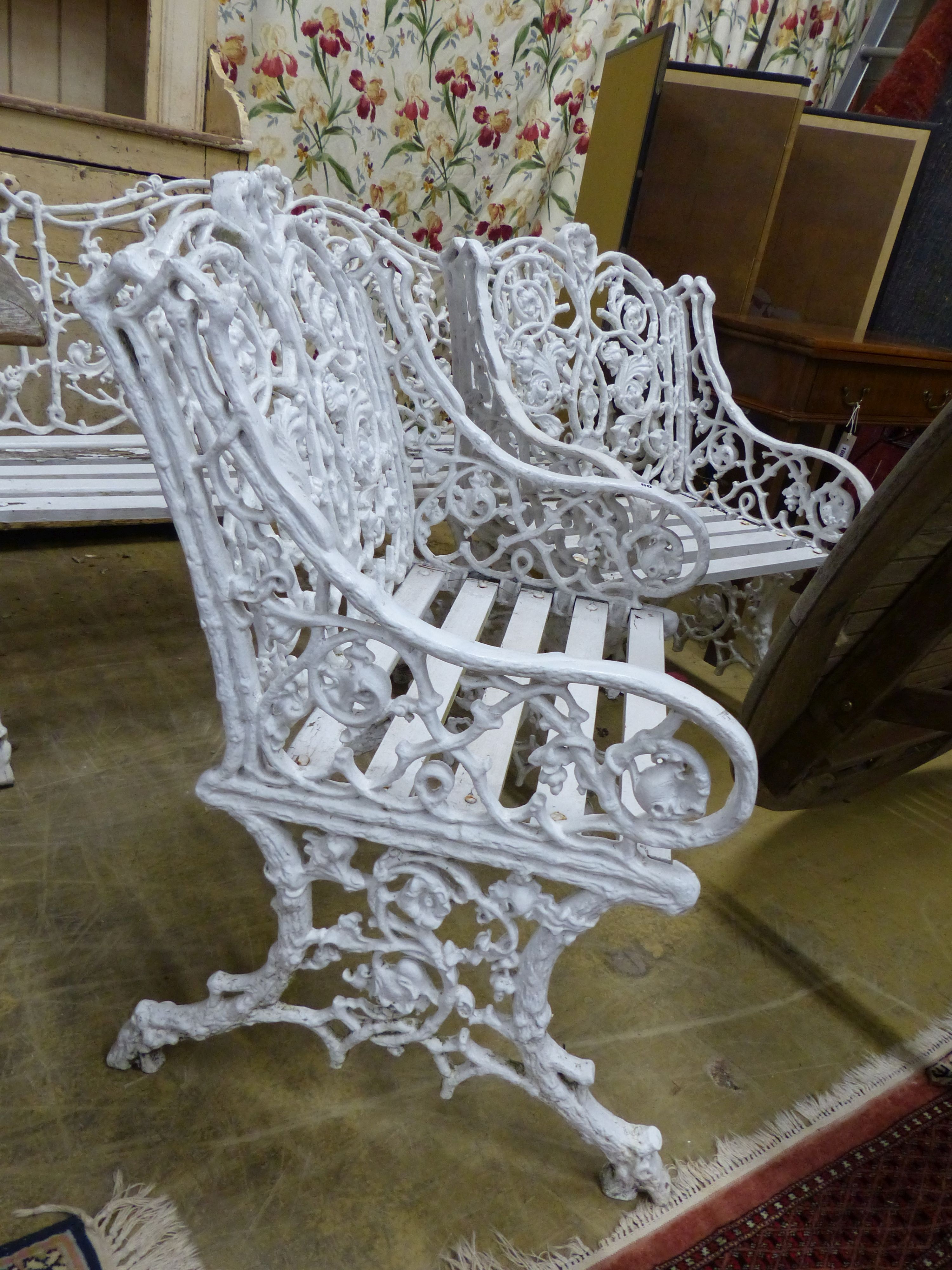 A Victorian style Coalbrookdale design painted metal garden bench and two armchairs, bench W.126cm D.60cm H.90cm